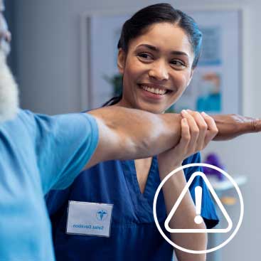 Smiling physiotherapist assisting patient with arm therapy in a clinical setting.